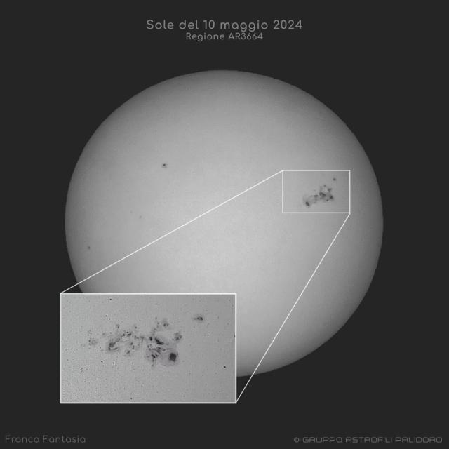The Sun is shown in black and white showing dark sunspots on the far right. The large sunspot group is expanded in an inset image at the bottom left.