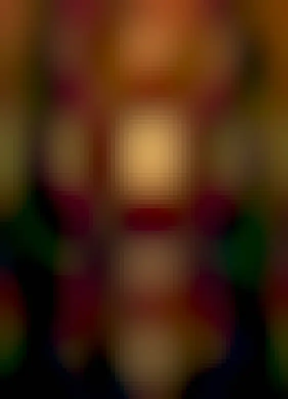 A distant Sun is seen over water and between foreground trees. On the lower part of the Sun is the gigantic active region AR 3664 visible by its dark sunspots.