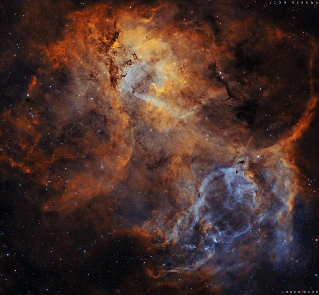 A starfield is shown with a large colorful emission nebula in the center. The outline of this emission nebula has a resemblance to a lion.