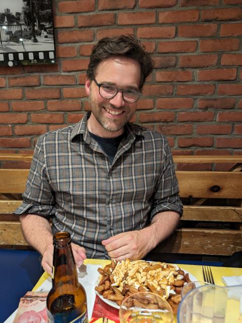 Nathan Schneider with a classic poutine and a blonde beer