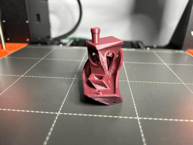 A benchy printed in merlot red PLA that is twisted 90 degrees around the Z axis.  This view is from the stern at the bottom, and looking in through the side door at the top.