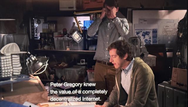 Two characters are in a garage. One is going through a notebook. 

Caption reads: Peter Gregory knew the value of a completely decentralized Internet.