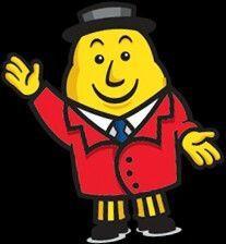 Irish Mr Tayto wearing a black hat, red jacket, white shirt, blue tie, yellow and black striped trousers, and black shoes
