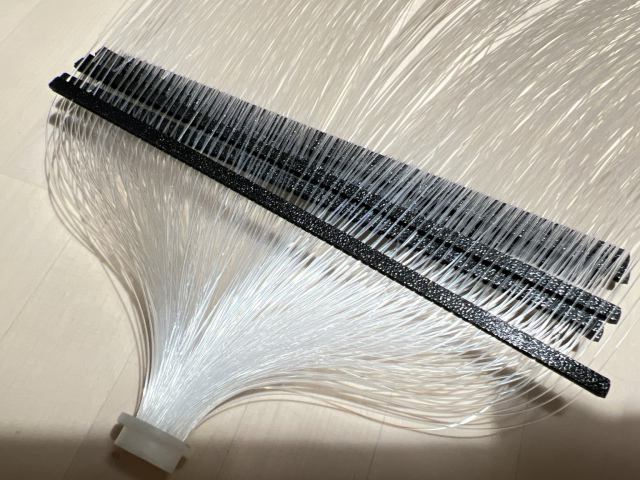 The wand has now had each strand of fibre individually threaded through a hole in a jig of some sort. 