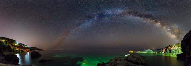 "Πανόραμα της παραλίας του Μυλοπόταμου στην Τσαγκαράδα με τον Γαλαξία να περνά πάνω στον νυχτερινό ουρανό."

GrigorisKoulouriotis, CC BY-SA 4.0, via Wikimedia Commons.