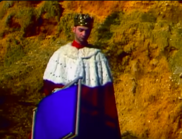 Dave Gahan with crown, king's robe and a deck chair.