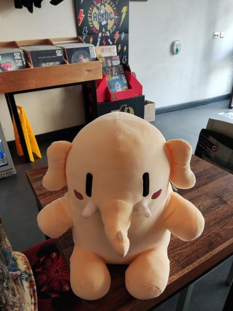 Mastodon plushy toy on a table infront of records 