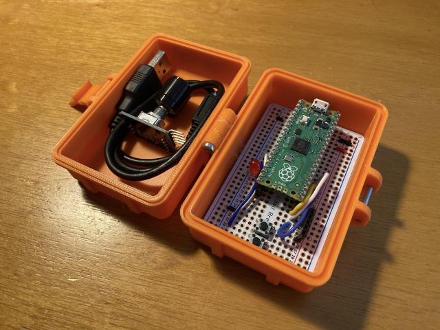 A 3D printed rugged box with a microcontroller and USB cable.