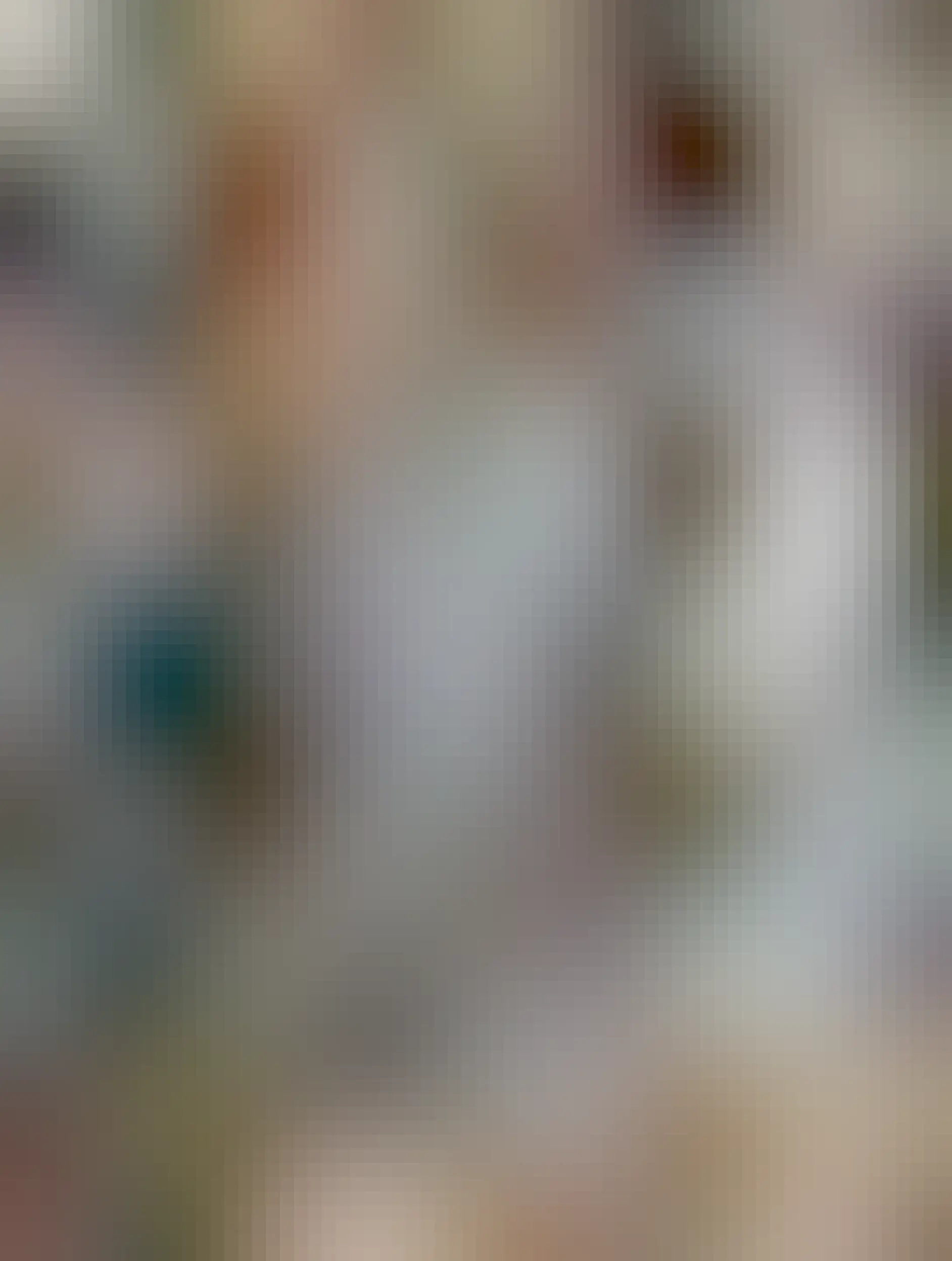 Two Labrador retriever pups sitting and looking up at the camera. One has a mostly black coat with floppy ears and one brown eye and one blue eye. The other is white and black with pointy ears and two stunning blue eyes. 