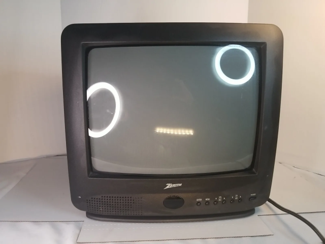 crt tv powered off and reflecting two ring lights and a line light in the shape of a confused face (O_o)