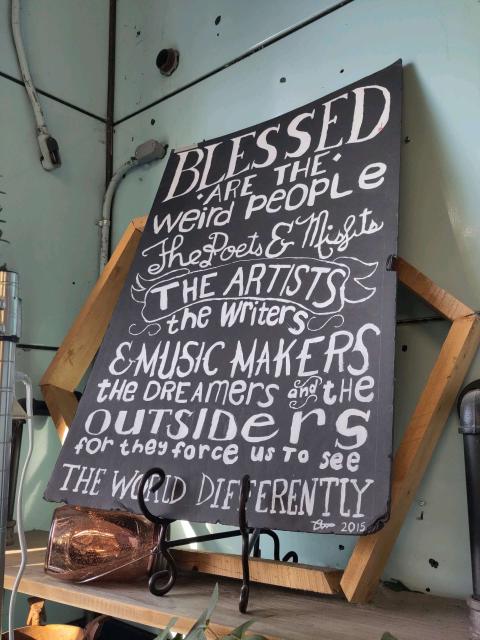 A handmade poster that begins "blessed are the weird"