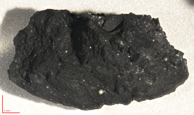 "Sample of asteroid (162173) Ryugu retrieved by Hayabusa2 sample return mission. At about 10 mm long, this fragment (ID C9000(CXL)) is the largest particle registered in the Ryugu Sample Database."

ISAS/JAXA, CC BY 4.0, via Wikimedia Commons.
