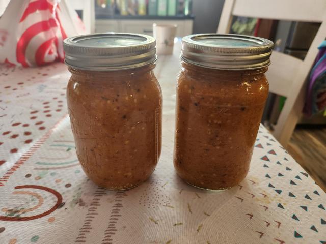 Two small jars of hot sauce on a table