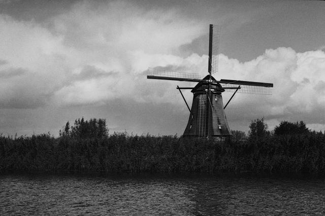 A view of a windmill across a canal