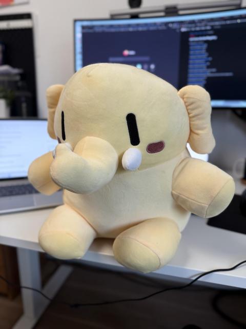 Mastodon Plushie sitting on my desk.
Computer screens in the background.