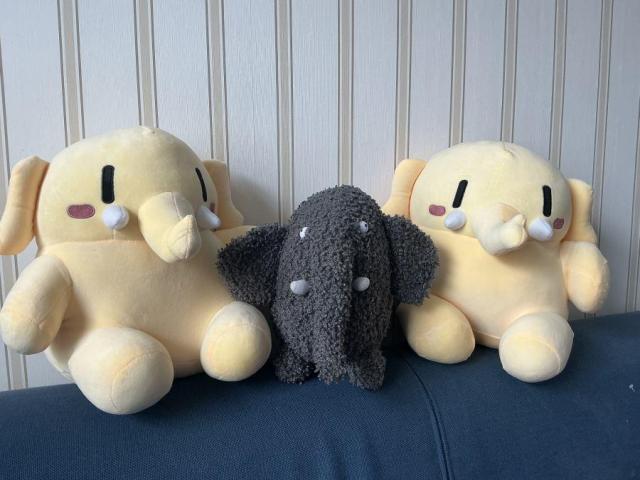 Olli uit Diergaarde Blijdorp zit tussen twee Mastodon plushie's.