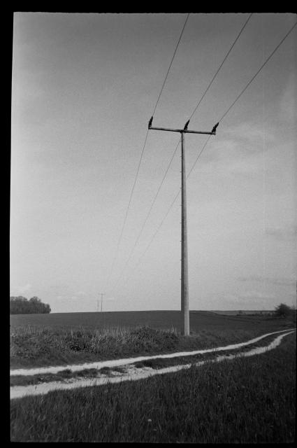 A picture of a field with electricity poles running into the distance