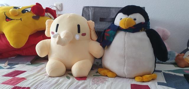 Plushtodon al lado de otro peluche de Tux. También aparece otro peluche que es una estrella.