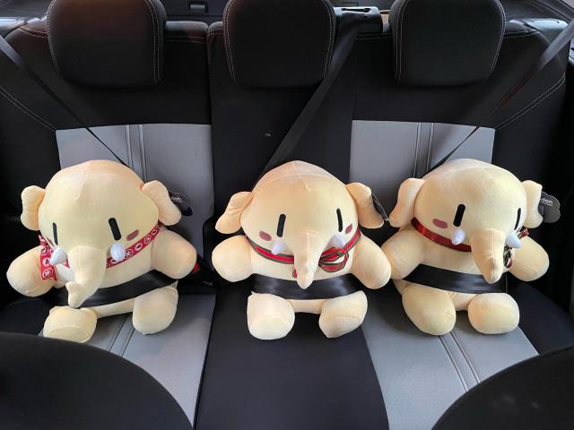 Photo of three Mastodon plushies on the back seat of a car