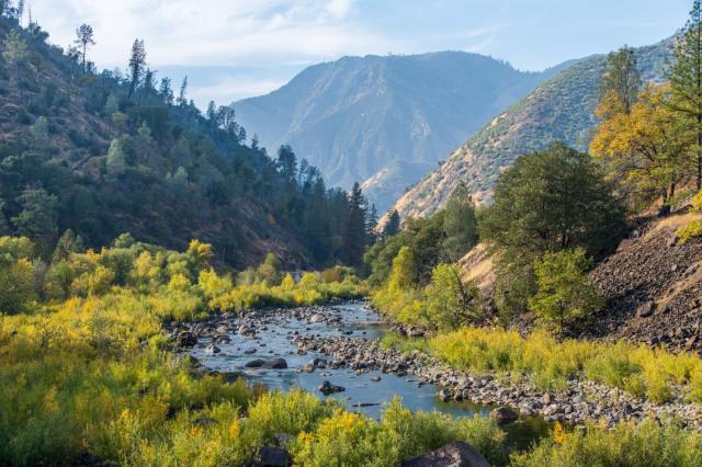 Amidst hills and yellowing leaves, a rocky river winds down a valley. [Fuji X-T5 / Tamron 18-300]