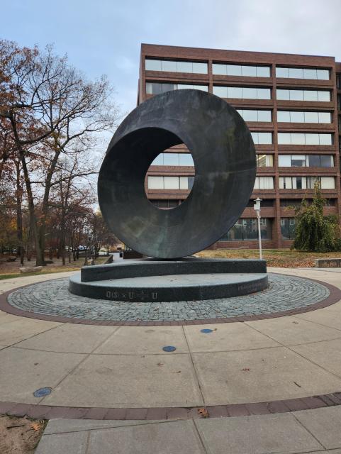 Statue on the Stony Brook campus of a large torus fashioned into a mobius strip