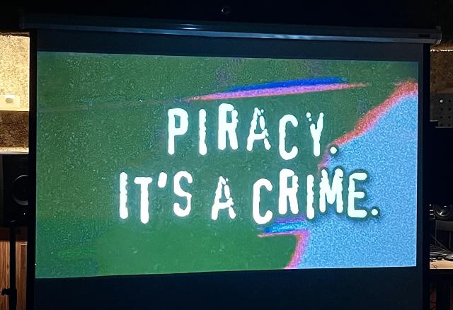 Projector screen: "Piracy. It's a crime."