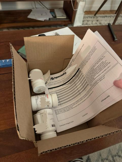 a heavily redacted box of three pill bottles from CVS speciality.