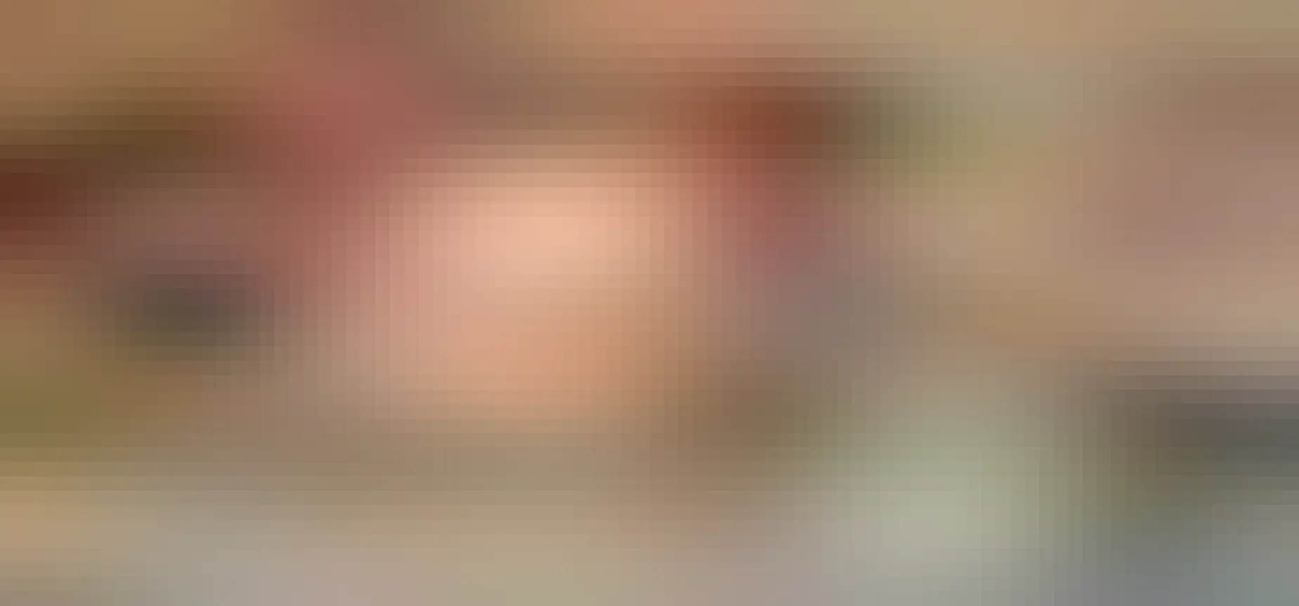 Chocolate cake with pink icing with a smiling axolotl face and pink rock candy gills.