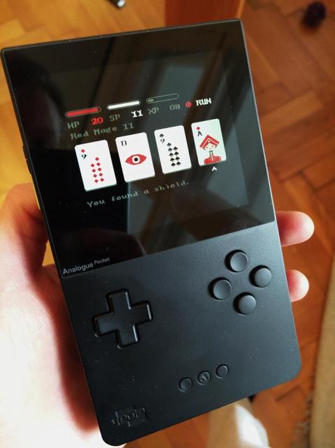 Photo of an Analogue Pocket handheld console, running the game Donsol, by 100 Rabbits