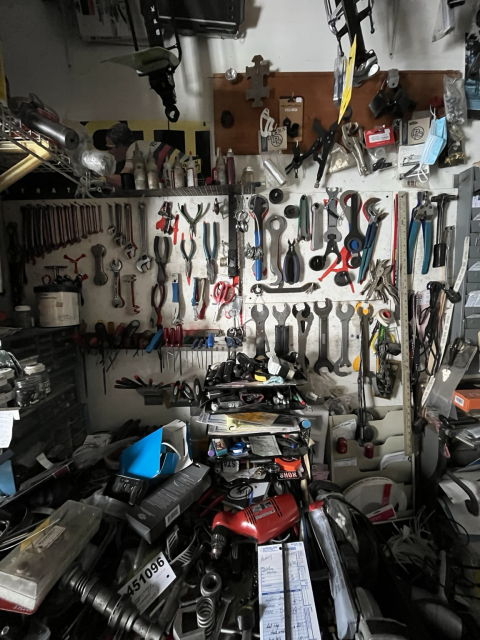 Scene from a bike shop with a wall covered in tools