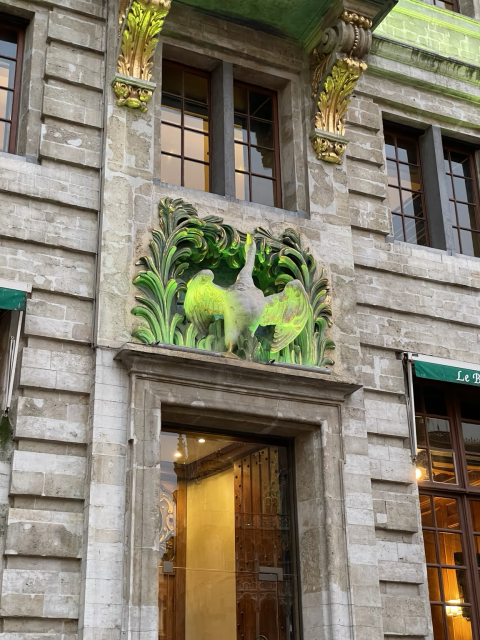 A goose ornament on the central plaza of Brussels, illuminated by green light from below. 