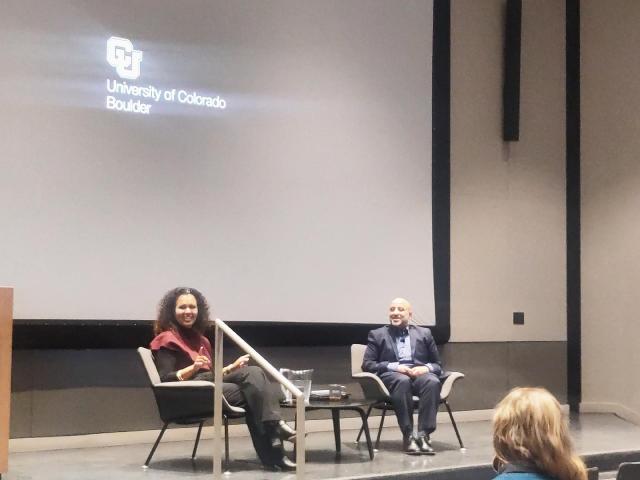 Safiya Noble seated on stage along with Bryan Semaan under the CU Boulder logo