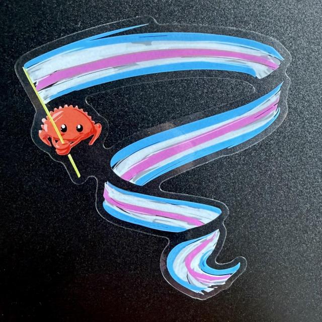 Sticker of an orange crab waving a giant trans flag banner; the die cut sticker has a transparent background so the waves of the banner look like it's in multiple pieces
