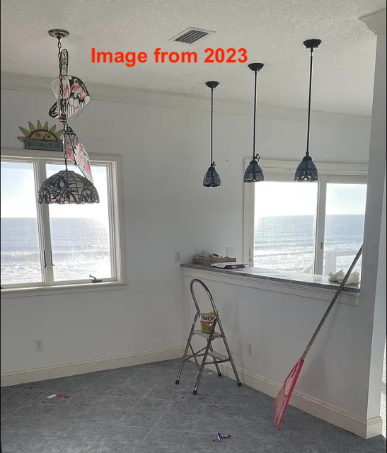 A photo of the inside of a house with windows with the ocean visible right outside, I added a label saying "image from 2023". 