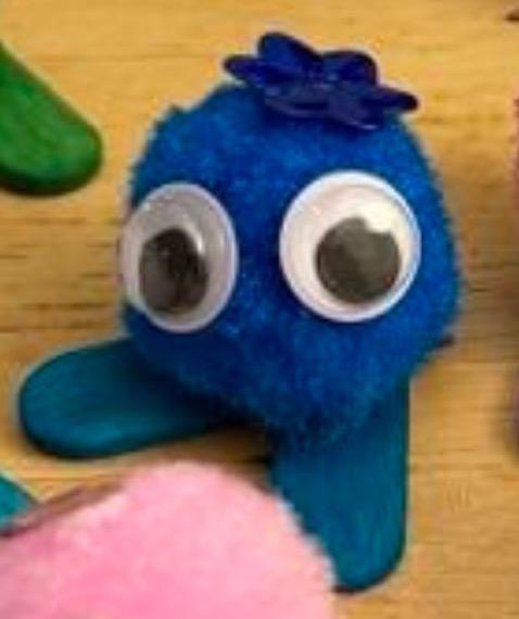 A blue Pom Pom pet with a blue flower on its head