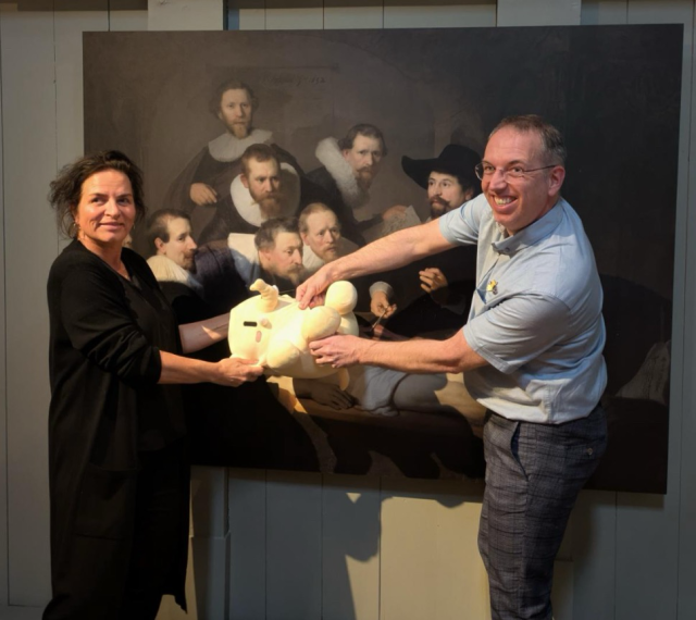 Koen and Marleen if front of a picture of ‘de Anatomische Les’ in de Waag.