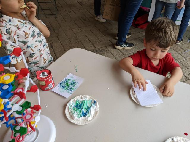 Table with DNA duplex model and a little kid doing a coloring activity