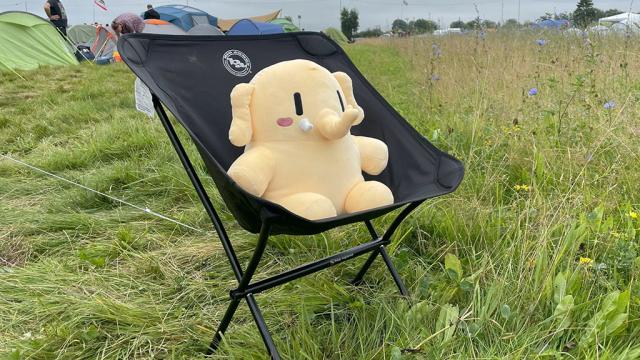 The #Plushtodon sitting in a chair in a grassy field.