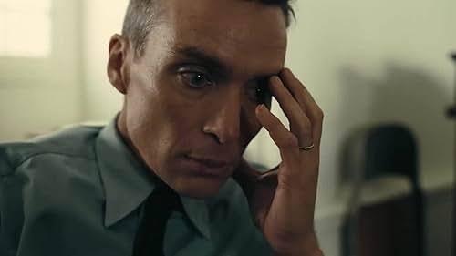 Cillian murphy from the movie Oppenheimer. he's holding his head in his hand and has a thousand yard scare. he is deeply unsettled by what he has done
