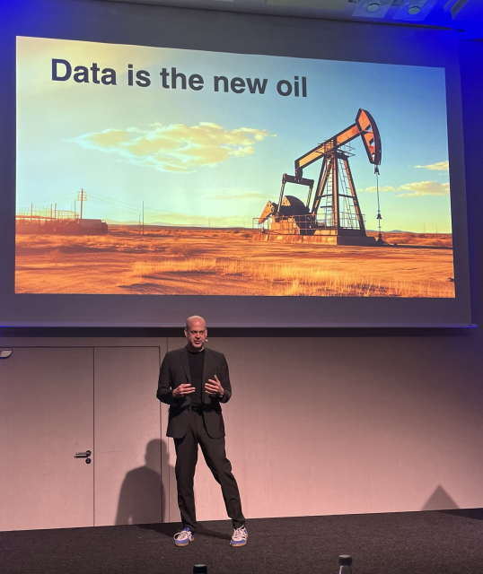 Frank on stage with a presentation that shows an oil drill and the text Data is the new oil!