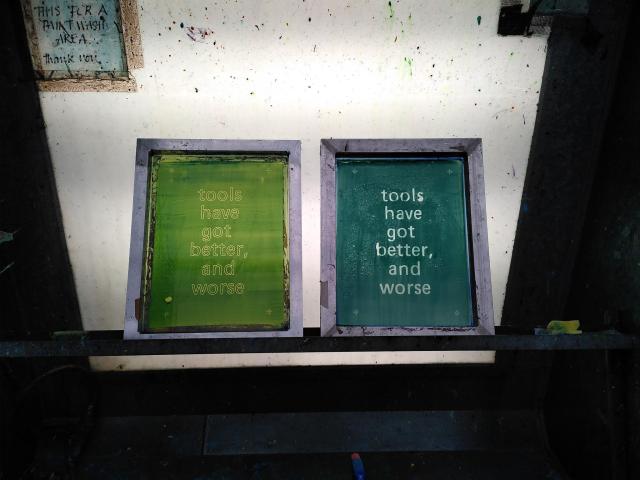 two silkscreens in a cleaning bay with the words "tools have got better, and worse" on them