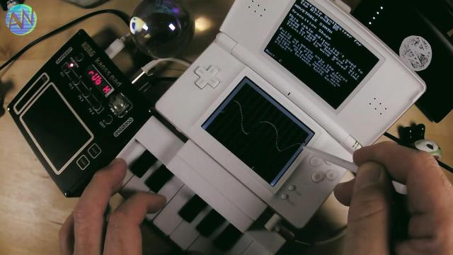 Nintendo DS showing a sine-ish wavetable in a hoembrew app, a tiny piano keyboard accessory attached the width of the DS, and a KORG NTS-3 kaoss pad. AudioWanderer plays with one hand on keyboard and one on the stylus.