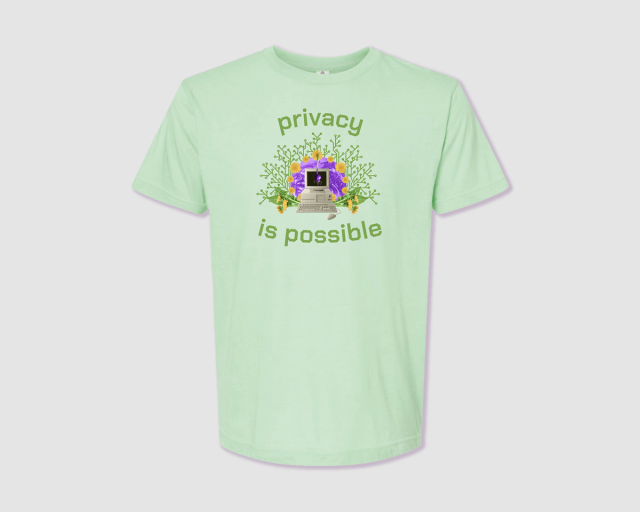 A lightgreen t-shirt with the tag line "privacy is possible" around an illustration of a 90s desktop computer that has flowers growing out of it