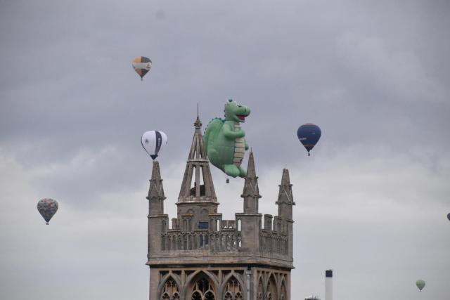 Hot air balloons against a church spire