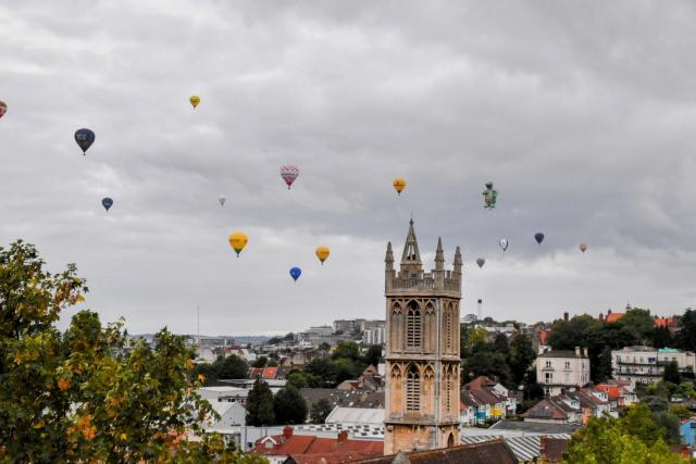 Several hot air balloons over a city