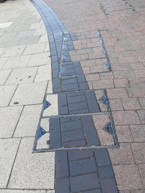 Some tlles in the footpath that are terribly badly laid oit