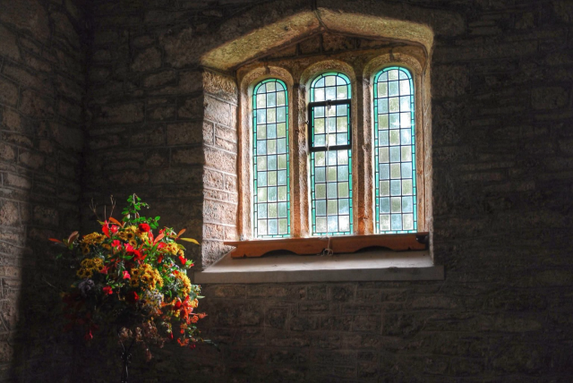 A church window with harvest festival flowers.