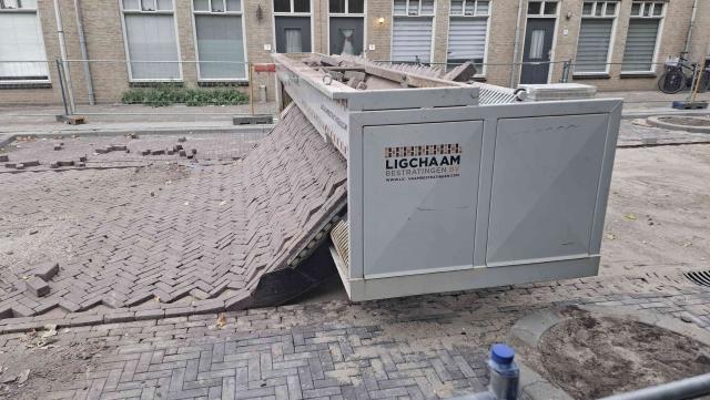 A 5 meter wide, 1-ish meter high, 2 meter deep machine that emits a brick street in a fishbone pattern at a 45 degree angle from the long end. it stands as wide as the road, basically laying down the road as it goes.