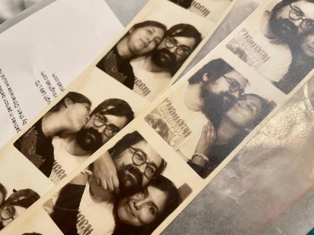 A close up of 2 black and white photo strips of a man and a woman trying to fit in the frame while also posing for the camera.