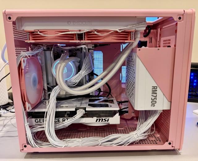 late 2025 mid-tier PC mini-ITX spec build, pink case (Veetro M06), white components -- AMD 7800X3D, GeForce RTX 5070, 32gb Crucial DDR5, Corsair 750w PSU, Gigabyte X780I pro mobo